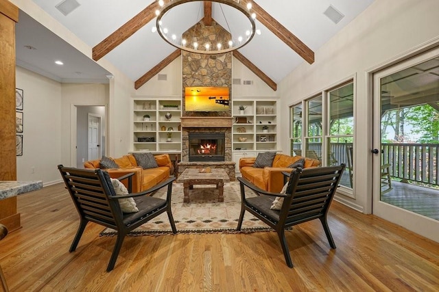 living room featuring light hardwood / wood-style flooring, a fireplace, high vaulted ceiling, and a chandelier