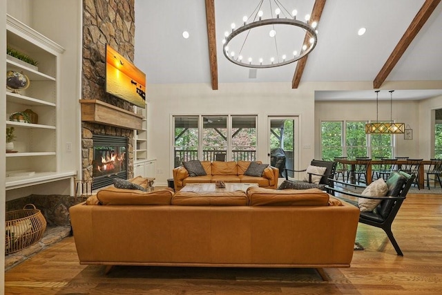 living room with beam ceiling, built in shelves, a fireplace, and wood-type flooring