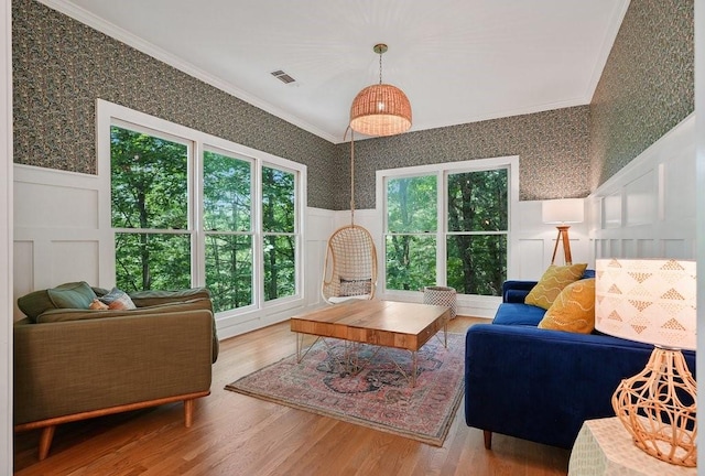 living room featuring hardwood / wood-style floors, a wealth of natural light, and ornamental molding