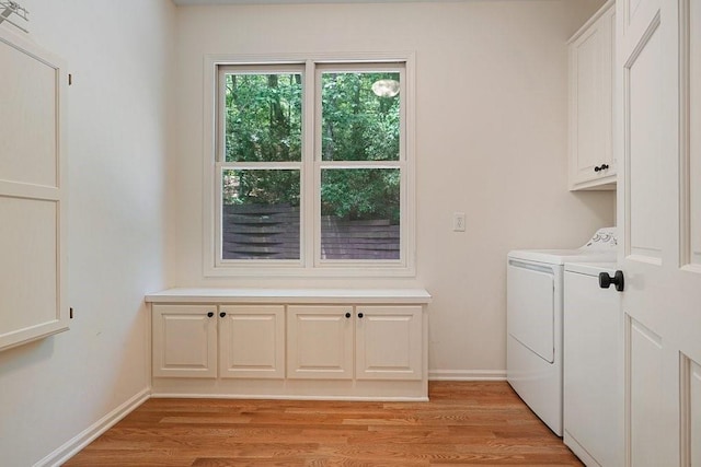 laundry area with cabinets, independent washer and dryer, and light hardwood / wood-style flooring