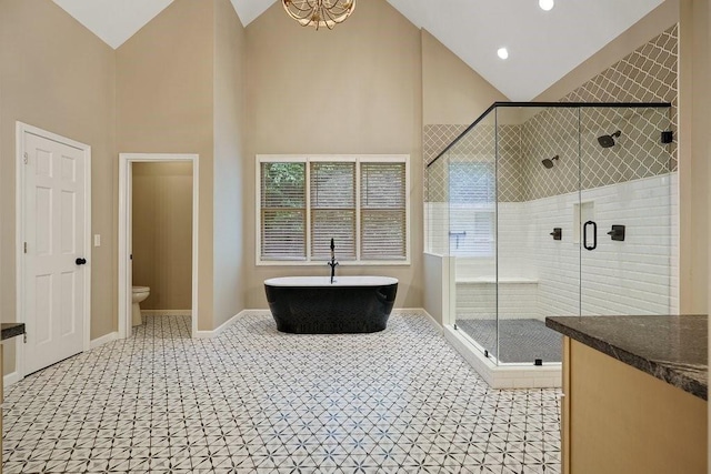 full bathroom featuring vanity, an inviting chandelier, high vaulted ceiling, plus walk in shower, and toilet