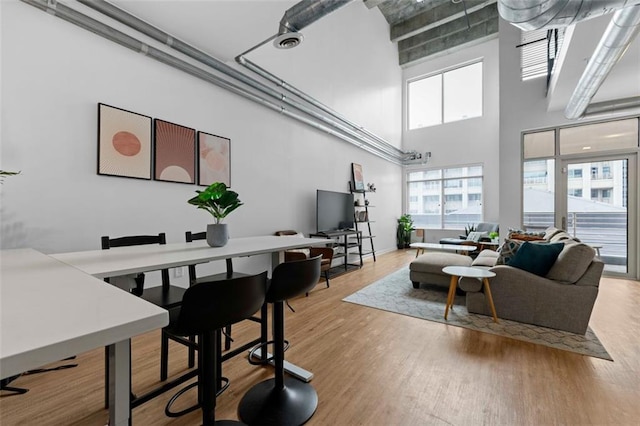 living room with hardwood / wood-style flooring and a towering ceiling