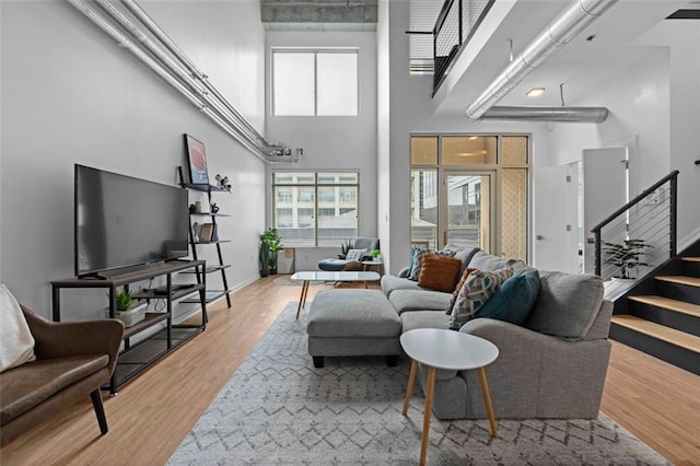 living room featuring a towering ceiling and hardwood / wood-style floors