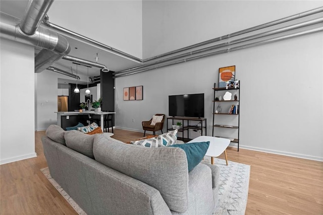 living room featuring a towering ceiling and hardwood / wood-style floors