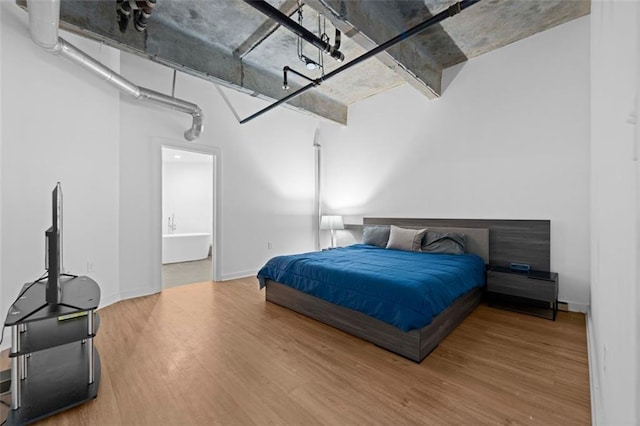 bedroom featuring ensuite bathroom and wood-type flooring