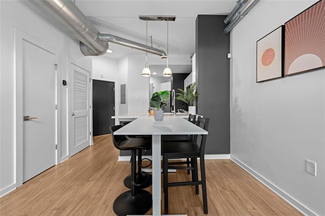 dining space with light hardwood / wood-style flooring and electric panel