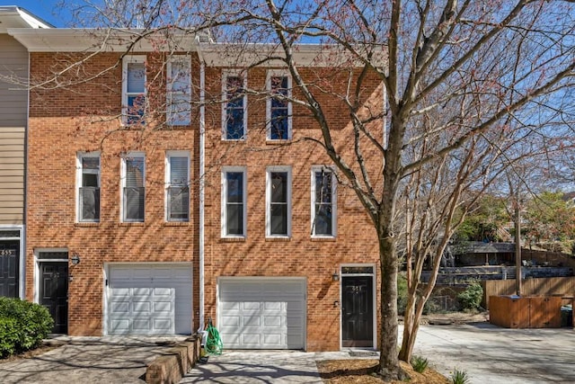 view of front of house featuring concrete driveway, a garage, and brick siding