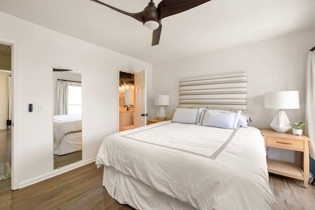 bedroom with ceiling fan, ensuite bathroom, baseboards, and wood finished floors