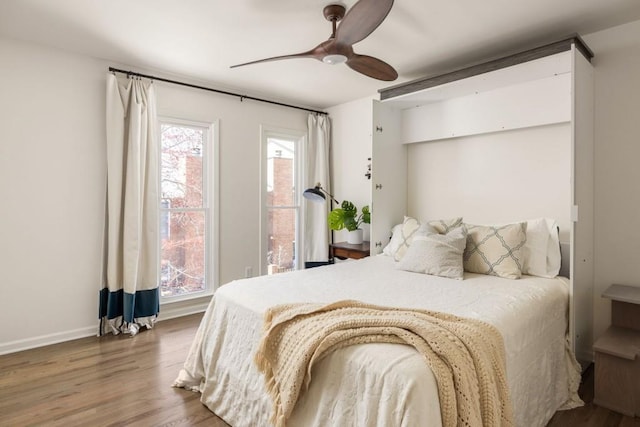 bedroom with baseboards, a ceiling fan, and wood finished floors