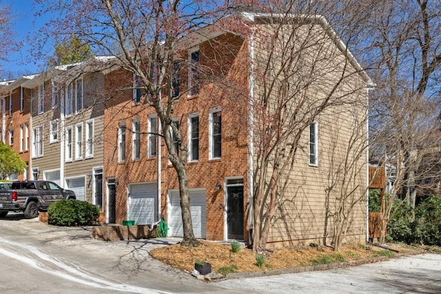 view of front of home featuring a garage, brick siding, and driveway