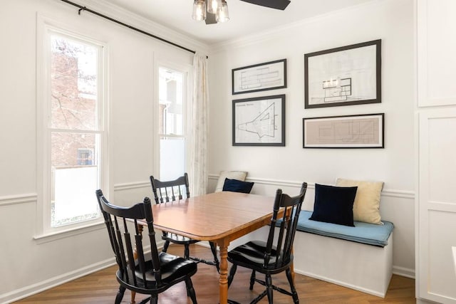 dining area featuring a ceiling fan, crown molding, and wood finished floors