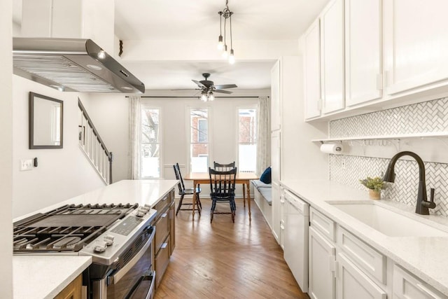 kitchen with stainless steel range with gas stovetop, white cabinets, dishwasher, and a sink