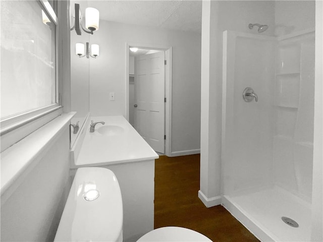 bathroom featuring vanity, a textured ceiling, hardwood / wood-style flooring, and walk in shower