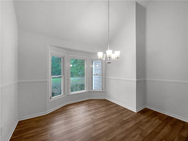 unfurnished room with a notable chandelier and dark hardwood / wood-style flooring