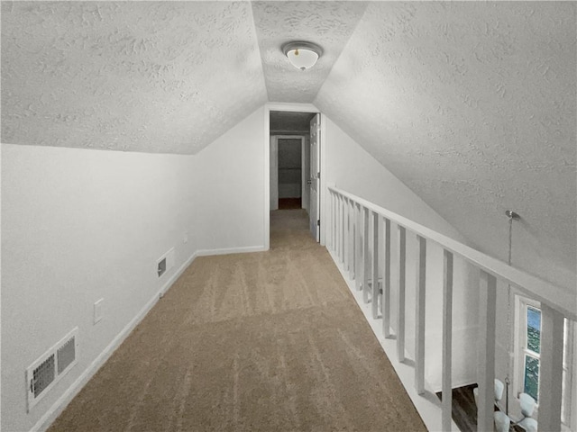 bonus room with carpet flooring, a textured ceiling, and vaulted ceiling