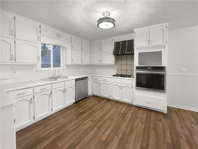 kitchen featuring appliances with stainless steel finishes, dark hardwood / wood-style flooring, extractor fan, sink, and white cabinets