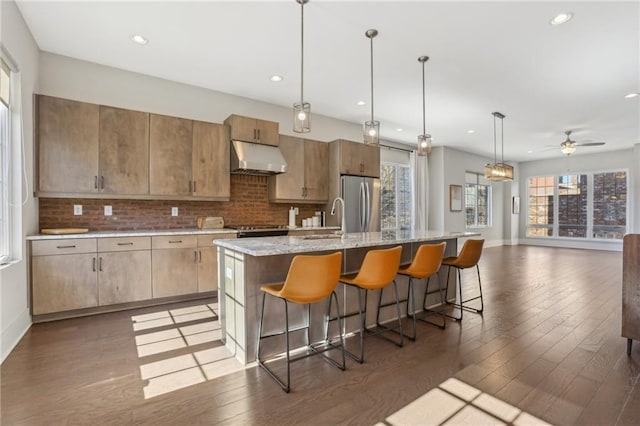 264 Castleberry Station Dr SW, Atlanta, GA 30313 - kitchen with an island with sink, freestanding refrigerator, a sink, under cabinet range hood, and backsplash