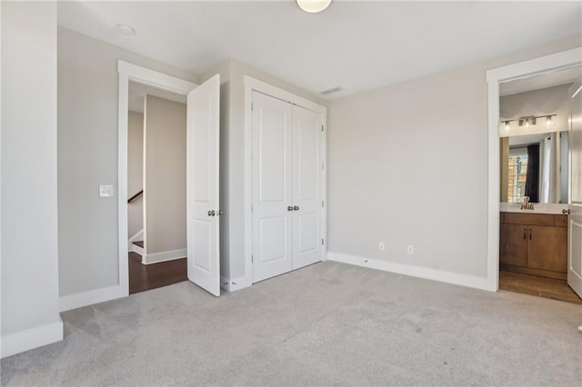 264 Castleberry Station Dr SW, Atlanta, GA 30313 - unfurnished bedroom with ensuite bath, a closet, baseboards, and carpet flooring