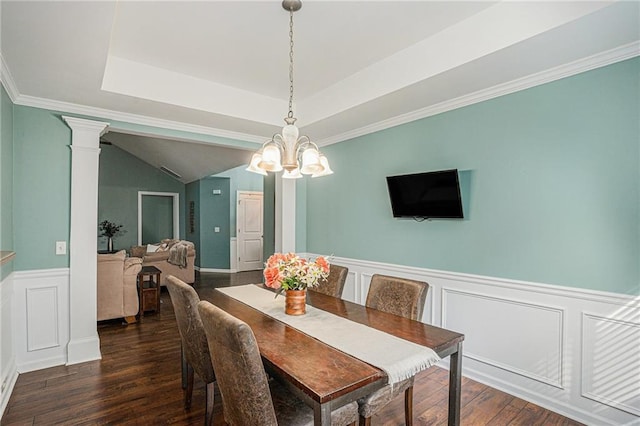 dining room with wainscoting, a decorative wall, a chandelier, wood finished floors, and ornate columns
