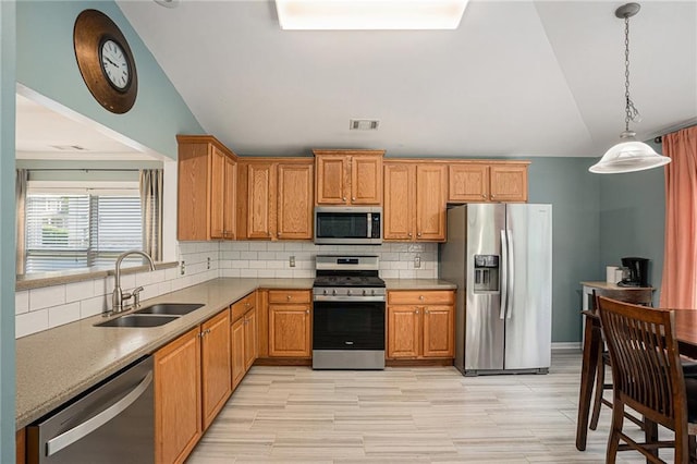 kitchen with visible vents, appliances with stainless steel finishes, a sink, and vaulted ceiling