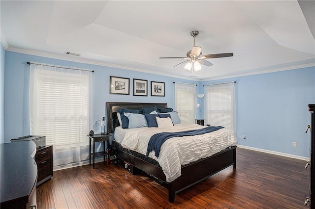 bedroom with crown molding, visible vents, wood finished floors, and a raised ceiling