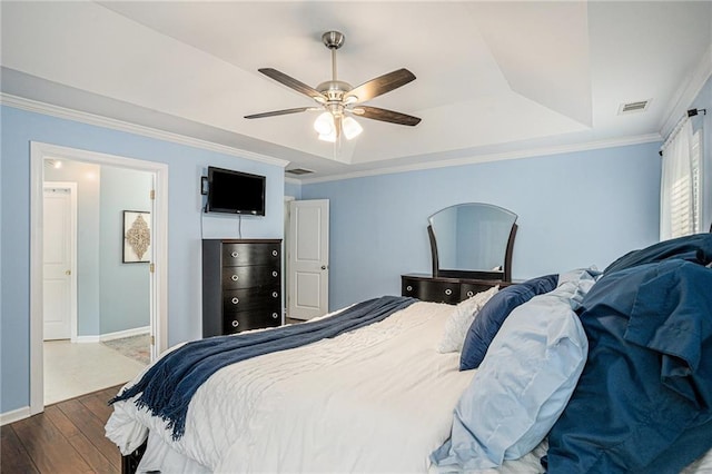bedroom featuring dark wood-style flooring, baseboards, a tray ceiling, visible vents, and ornamental molding