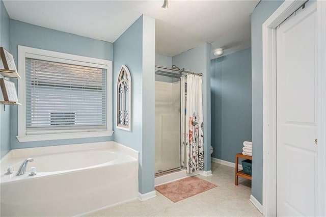 full bathroom featuring toilet, baseboards, a garden tub, and a stall shower