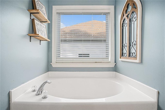 full bath with a bath and a wealth of natural light