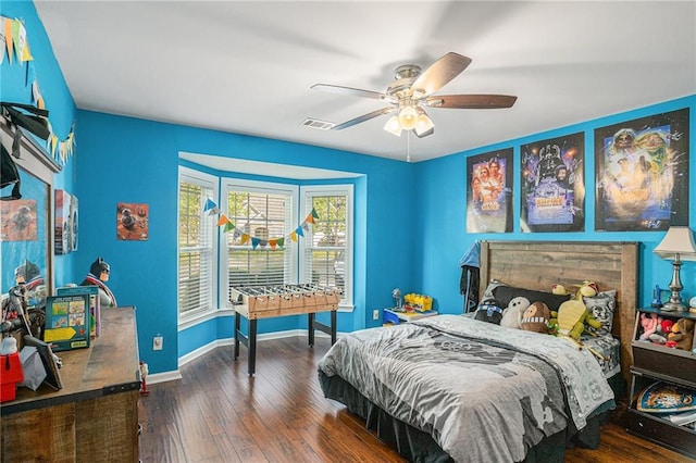 bedroom with a ceiling fan, baseboards, visible vents, and wood finished floors