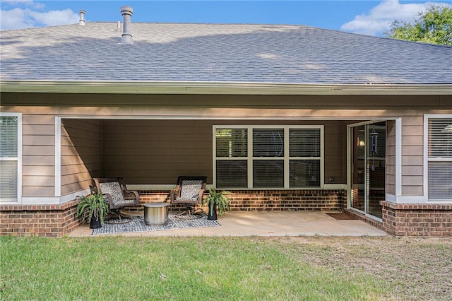 rear view of property with roof with shingles, a patio area, and a yard
