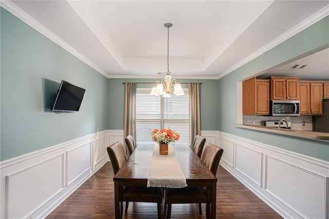 dining space featuring an inviting chandelier, a raised ceiling, dark wood-style flooring, and visible vents