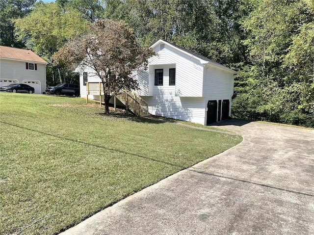 view of side of property with a garage and a lawn