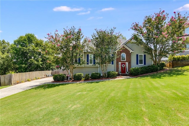 bi-level home with fence, a front lawn, concrete driveway, and brick siding