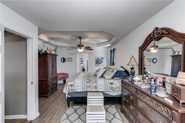 bedroom featuring a textured ceiling, ceiling fan, and light wood-style floors