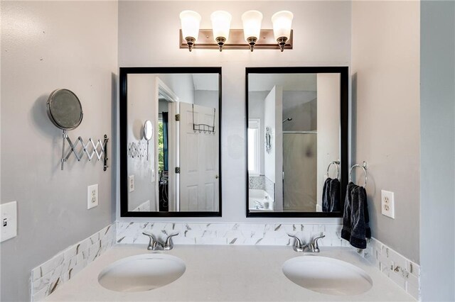 bathroom with double vanity, a sink, and a shower with shower door