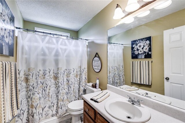 bathroom featuring toilet, a shower with shower curtain, a textured ceiling, and vanity