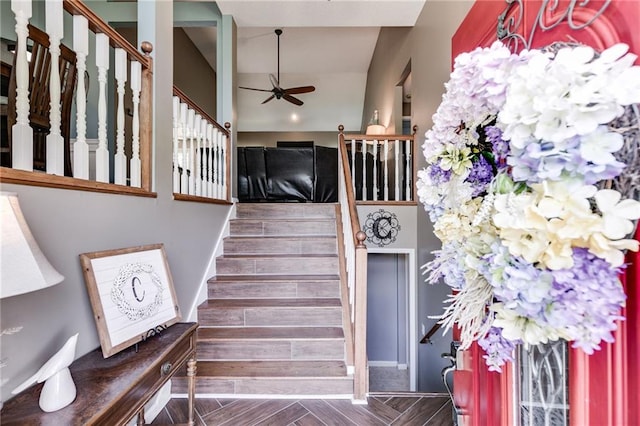 staircase featuring ceiling fan, wood finish floors, and baseboards