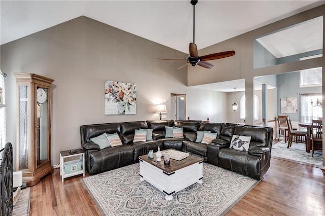 living area with a ceiling fan, high vaulted ceiling, and wood finished floors