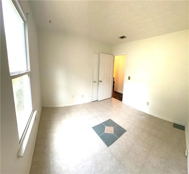 empty room with visible vents and a textured ceiling