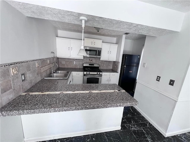 kitchen featuring stainless steel appliances, white cabinetry, a sink, a textured ceiling, and a peninsula