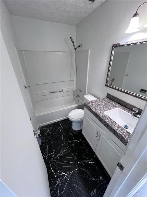 full bath featuring a textured ceiling, toilet, vanity, marble finish floor, and tub / shower combination