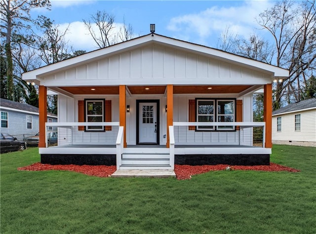 439 Bussey Ave, Thomson, GA 30824 - view of front of house with board and batten siding, a porch, and a front lawn