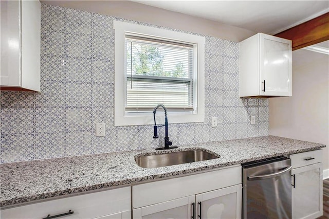439 Bussey Ave, Thomson, GA 30824 - kitchen with stainless steel dishwasher, backsplash, white cabinets, and light stone countertops