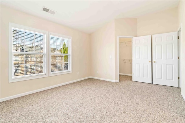 unfurnished bedroom with a closet, carpet floors, and a spacious closet