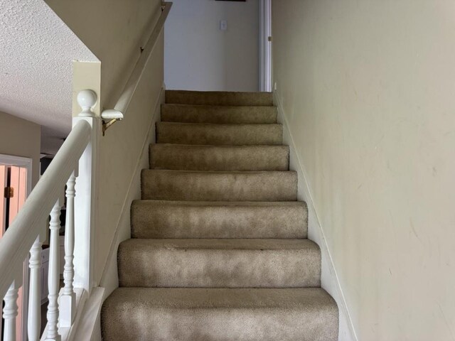 stairway with a textured ceiling