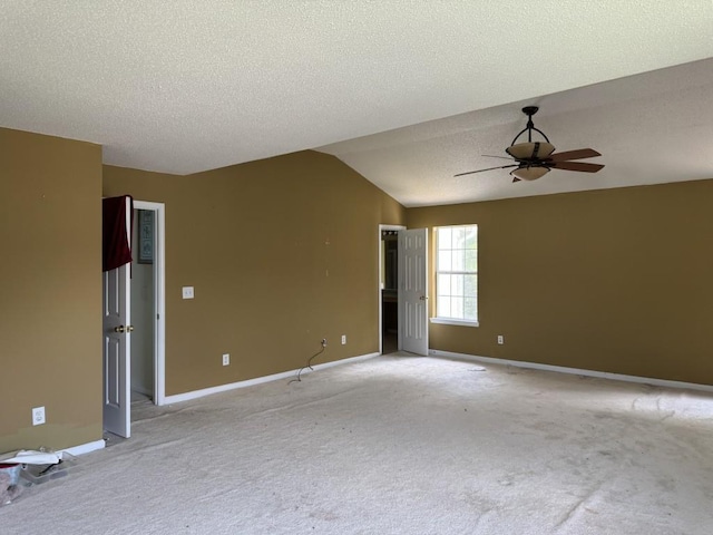 carpeted spare room featuring a textured ceiling, lofted ceiling, and ceiling fan