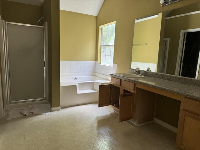 bathroom featuring vanity, independent shower and bath, lofted ceiling, and tile patterned floors