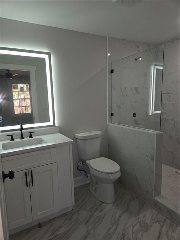 bathroom featuring tiled shower, vanity, and toilet