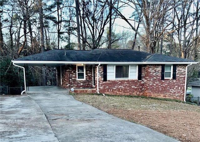 ranch-style home with a carport, concrete driveway, and brick siding