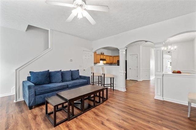 2826 Snapfinger Mnr, Decatur, GA 30035 - living room with ceiling fan, light wood-style floors, arched walkways, a textured ceiling, and decorative columns